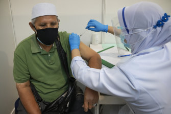 A man receives the Pfizer COVID-19 shot at an exhibition centre-turned vaccination hub in Kuala Lumpur, Malaysia.
