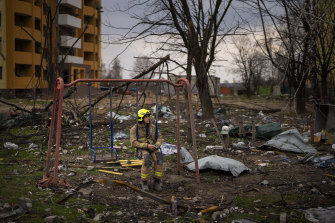 A firefighter sits on a swing next to a building destroyed by a Russian bomb in Chernihiv, Ukraine, on Friday.