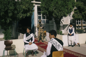 Students and Taliban officials attend a ceremony for the reopening of the schools at the Amani high school in Kabul.
