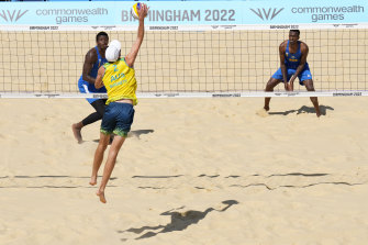 Australia’s Paul Burnett spikes the ball to Rwanda’s Venuste Gatsinzi (left) during their preliminary pool B beach volleyball match.