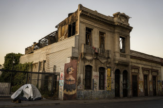 A tent next to a damaged building in the Yungay suburb of Santiago, Chile. The newly elected president, Gabriel Boric, moved into the neighbourhood to send a message about reviving areas that have fallen prey to crime and poverty. 