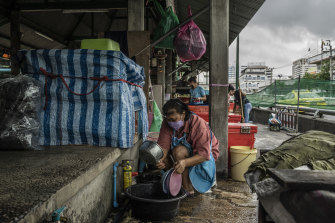 Jintana Rapsomruay washes dishes at a stall where she makes a popular dessert in Bangkok. “If I were the government, I would first take care of my people and fix the economy instead of making a fuss over a name for political reasons.”