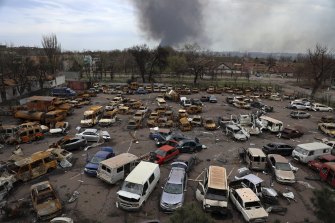 Damaged and burned vehicles are seen at a destroyed part of the Illich Iron & Steel Works Metallurgical Plant, as smoke rises from the Metallurgical Combine Azovstal during heavy fighting in Mariupol.