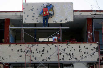 Workers repair the facade of City Hall riddled with bullet holes, in Villa Unio<em></em>n, Mexico, in 2019 after 22 people were killed in a gun battle between police and a heavily armed drug cartel assault group.
