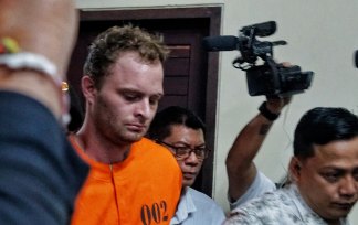 Drew Donal Ireland is led into a press conference in Bali on Tuesday.