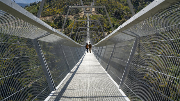 People walk across a narrow footbridge suspended across a river canyon, which claims to be the world’s longest pedestrian bridge, in Arouca, Portugal. 
