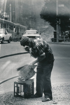 A man tries to protect his face from the storm. 