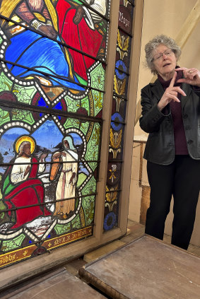 Holy Cross professor and stained-glass expert Virginia Raguin stands near the stained-glass window that depicts Christ speaking to a Samaritan woman, in the now-closed St Mark’s Episcopal church.