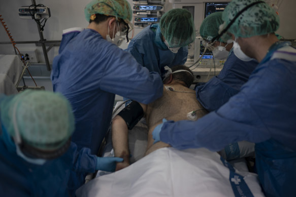 Healthcare workers assist a COVID-19 patient at a library that was turned into an intensive care unit (ICU) at Germans Trias i Pujol hospital in Badalona, Barcelona province, Spain.