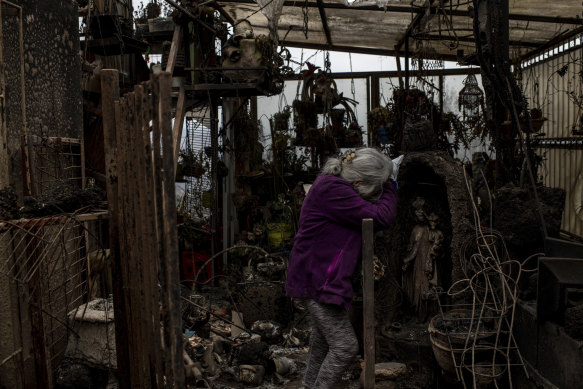 Uberlinda Silva weeps in the remains of her house.