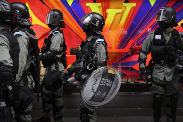 Riot police patrol near a Louis Vuitton store during a demonstration in Hong Kong's financial district.