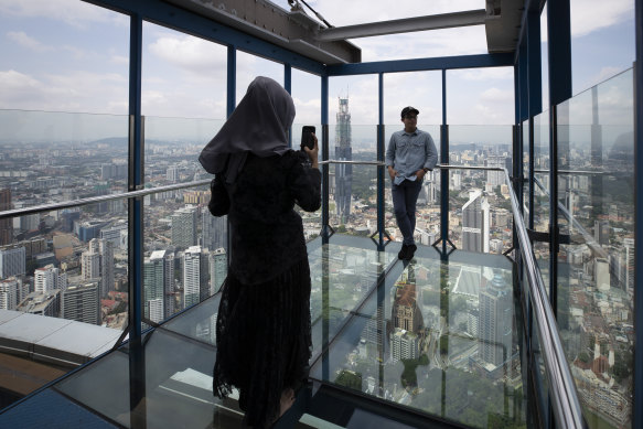 Tourists pose for photos at the Skybox in Kuala Lumpur. Malaysia has entered a 'Recovery Movement Control Order' after three months of coronavirus restrictions. 