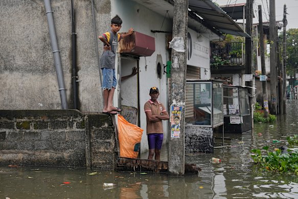 People stranded by floods wait in their submerged neighbourhood in Colombo, Sri Lanka on Saturday.
