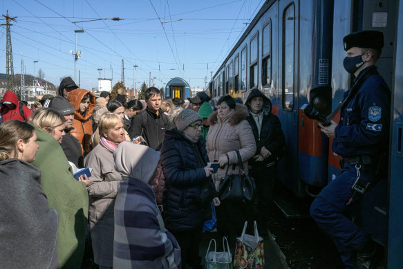 Refugees who fled Ukraine wait to get their passports stamped before boarding a train to Budapest in Zahony, a border town in eastern Hungary. President Biden is rethinking relationships with allies as well as rivals, including China, Iran and Venezuela, to counter President Vladimir Putin of Russia. 