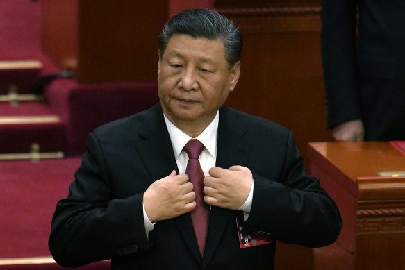 Xi Jinping adjusts his jacket during the closing session of the National People’s Congress on Monday.