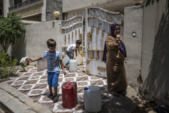 A family collects water jugs in Erbil, Iraq. A lack of municipal services in many areas has led residents to rely on private water delivery for all of their household needs. 