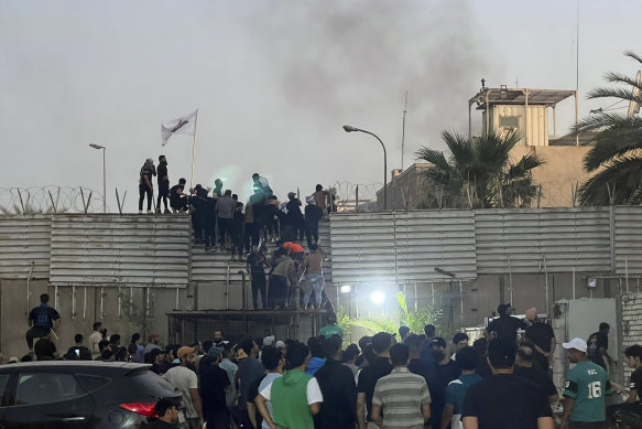 Protestocular Bağdat'taki İsveç büyükelçiliği önünde duvara tırmanıyor.