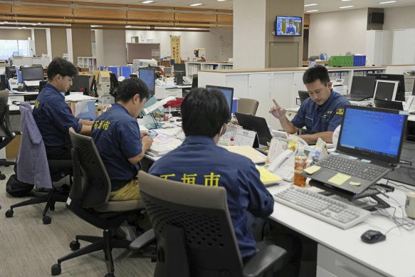 Officials of Ishigaki City in Japan gather at the city hall in response to a missile alert.