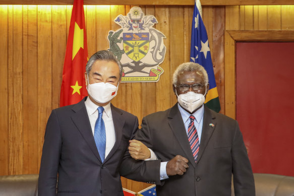 Solomon Islands Prime Minister Manasseh Sogavare, right, locks arms with visiting Chinese Foreign Minister Wang Yi in Honiara, Solomon Islands on May 26, 2022.