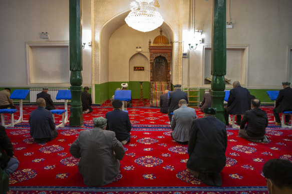 Uyghurs and other members of the faithful pray during services at the Id Kah Mosque in Kashgar in western China’s Xinjiang Uyghur Autonomous Region. Outside observers say scores of mosques have been demolished.