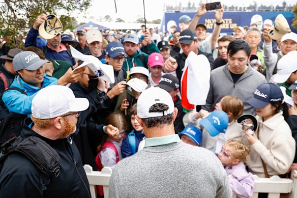 Rory McIlroy signs autographs for spectators.