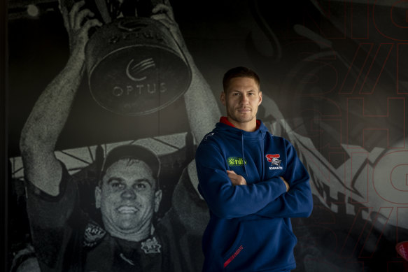 Kalyn Ponga in front of a mural of fellow Knights favourite Paul Harragon.