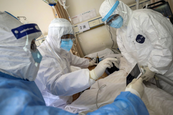 Medical personnel scan a new coronavirus patient at a hospital in Wuhan in central China's Hubei province. 