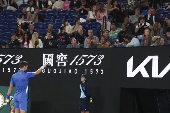 Novak Djokovic points to a spectator during his second round match against Alexei Popyrin at Melbourne Park.