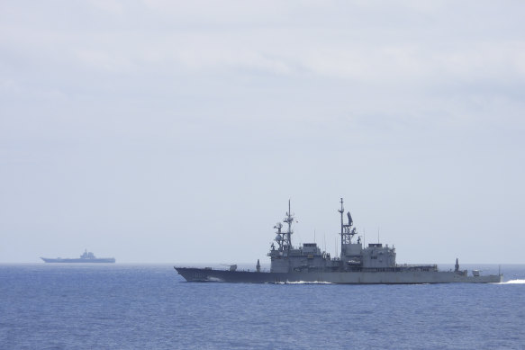 A Taiwanese navy ship Keelung, foreground monitors the Chinese aircraft carrier Shandong in the  background near Taiwanese waters.