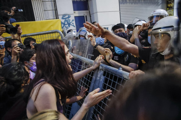 A protester, left, confronts police officers preventing the group from marching against the government’s decision to withdraw from Istanbul Convention, on Thursday, July 1, 2021. 