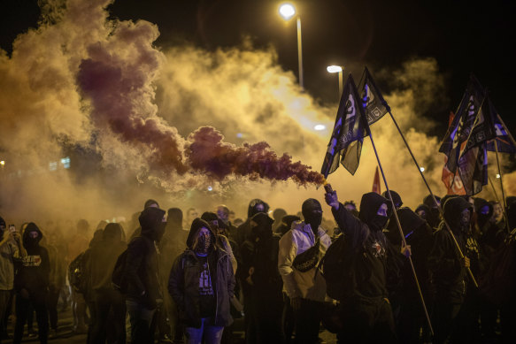 Masked, flare-waving demonstrators march in the Catalonian city of Girona on Tuesday.