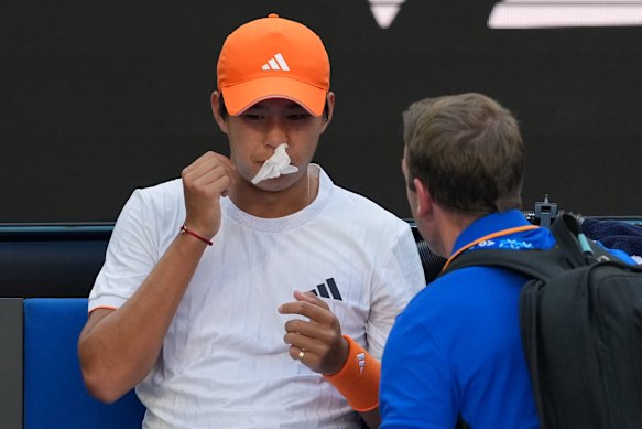 Learner Tien of the US receives treatment for a nose bleed during his fourth round match against Daniil Medvedev of Russia.