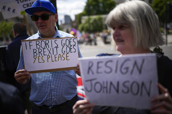 People protest outside the British parliament as Boris Johnson battles to prove he can stay on.