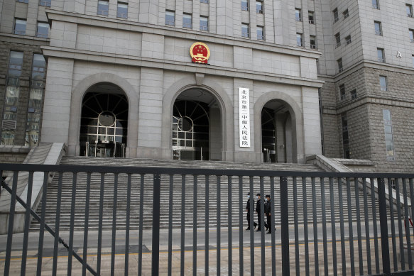 Policemen wearing face masks patrol at the compound of No. 2 Intermediate People’s Court in Beijing. 