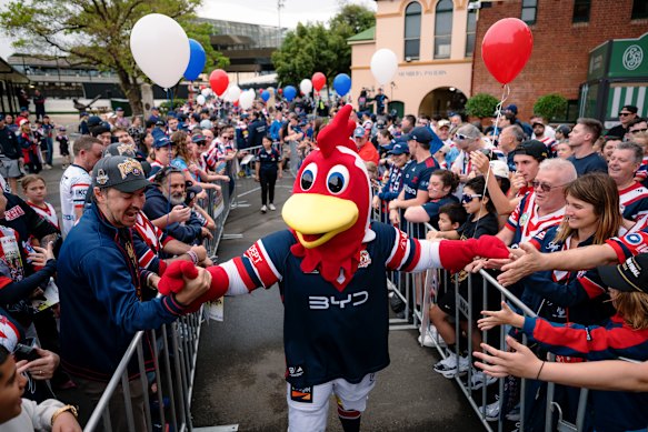 Club mascot Rocky the Rooster shakes hands with the flock.