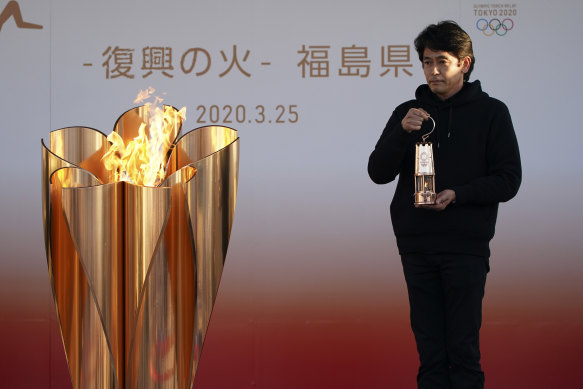 Keepers of the flame: an official holds a lantern containing the Olympic Flame  in Iwaki, northern Japan, on Wednesday.