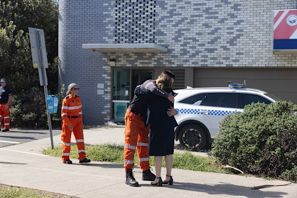 A volunteer embracing Ballina Mayor Sharon Cadwadaller amid mourning for two marine rescue volunteers.