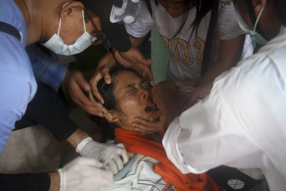 A woman is treated by a nurse after being tear-gassed during an anti-coup protest in Yangon on Tuesday.