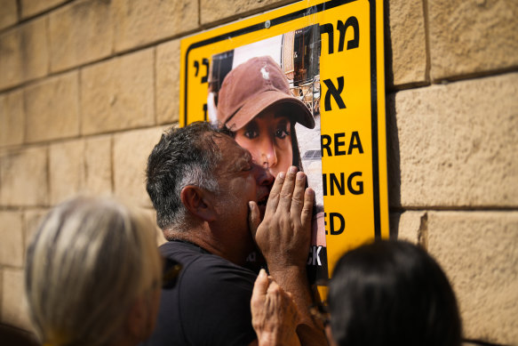 Eli Albag cries over the photograph of his daughter Liri, as he gathers with others during a protest in Tel Aviv demanding the release of dozens of Israelis who were abducted by Hamas.