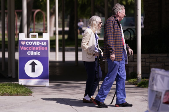 People leave a testing and vaccination clinic for COVID-19 in Long Beach, California.