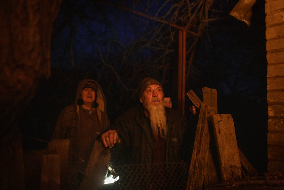 People watch a home burn after Russian shelling in Bakhmut on January 26.