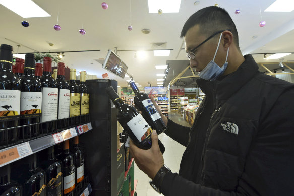 A man compares two bottles of Australian wine at a supermarket in Hangzhou in east China’s Zhejiang province.