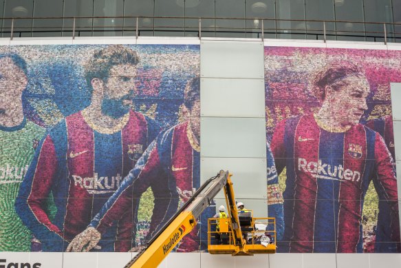 An image of Lionel Messi is removed from Camp Nou, Barcelona’s home stadium, after his move to Paris was confirmed.