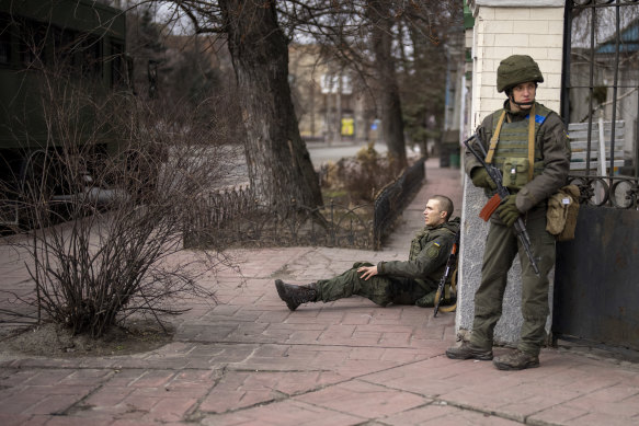 A Ukrainian soldier sits injured in cross fire inside the city of Kyiv.