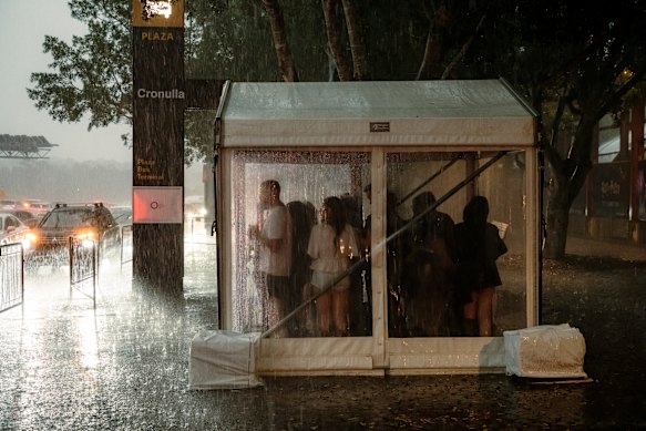 People huddle for cover at Sydney Olympic Park.