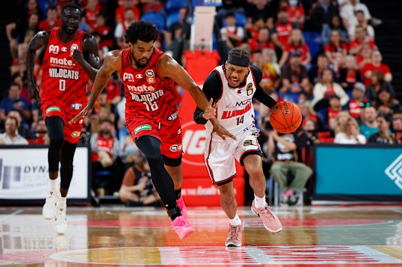 Biwali Bayles of the Hawks attempts to break clear down the court as Mason Jones of the Wildcats tries to stop him.