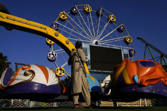 A Taliban fighter stands guard in an amusement park, in Kabul, Afghanistan, on Thursday. Women are now banned from parks and gyms as well.