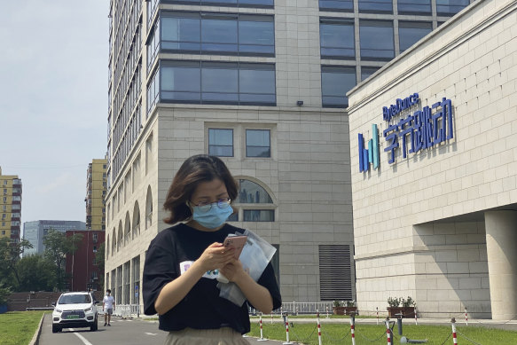 A woman checks her phone outside the headquarters of TikTok owner ByteDance in Beijing. 