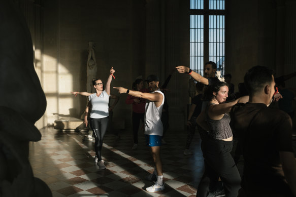 Participants strike a John Travolta pose at the Louvre Museum in Paris.