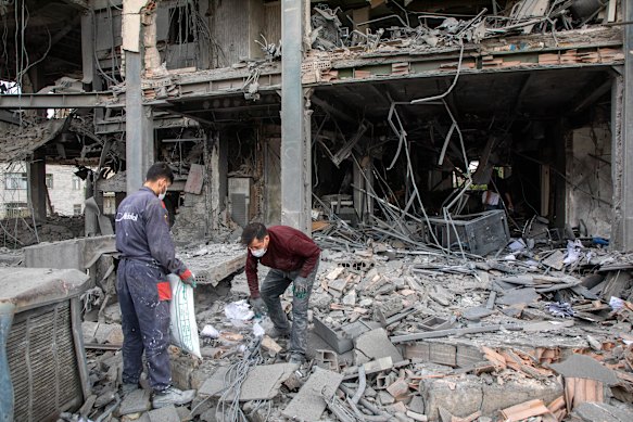 Iranians sift through a building in Tehran destroyed by a US-Israeli strike.